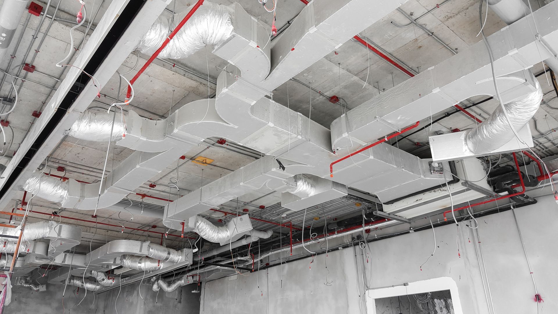 A room with a lot of pipes hanging from the ceiling.