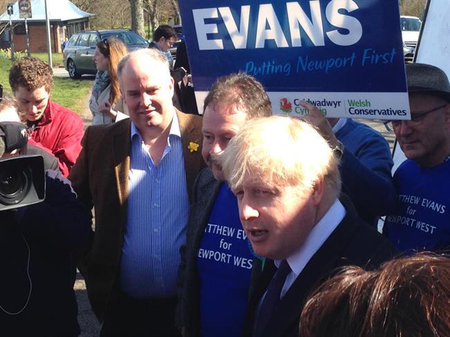 A group of men standing in front of a sign that says evans