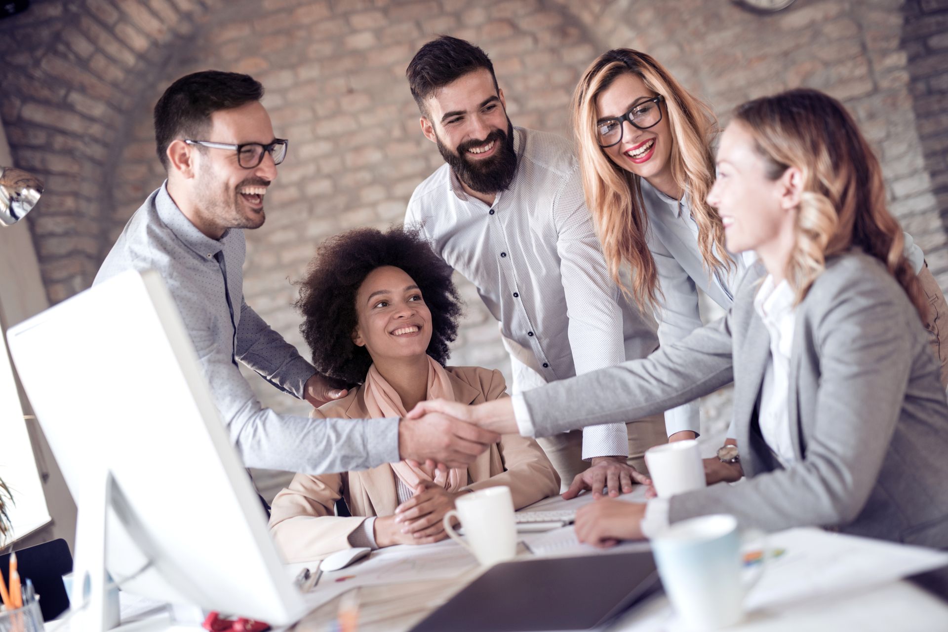 A group of people are shaking hands in an office.