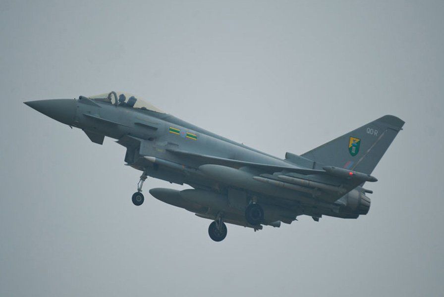 A fighter jet with the letter o on the tail is flying in the sky