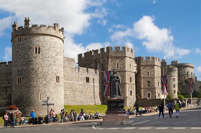A large stone castle with a statue in front of it