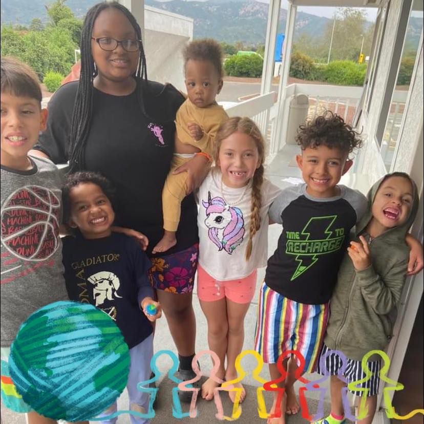A group of children posing for a picture including one wearing a shirt that says gladiator