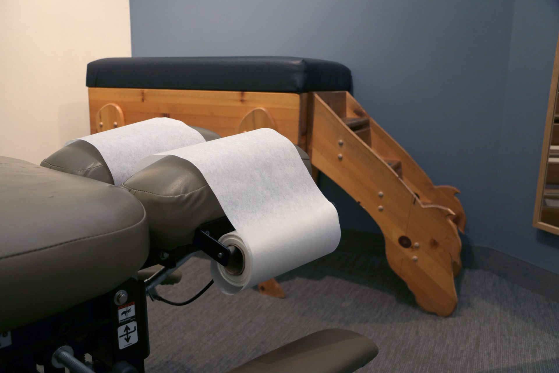 Two rolls of paper towels are attached to a massage table