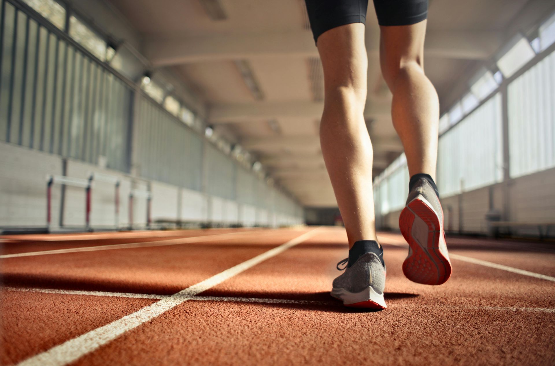 A person is running on a track in a gym.