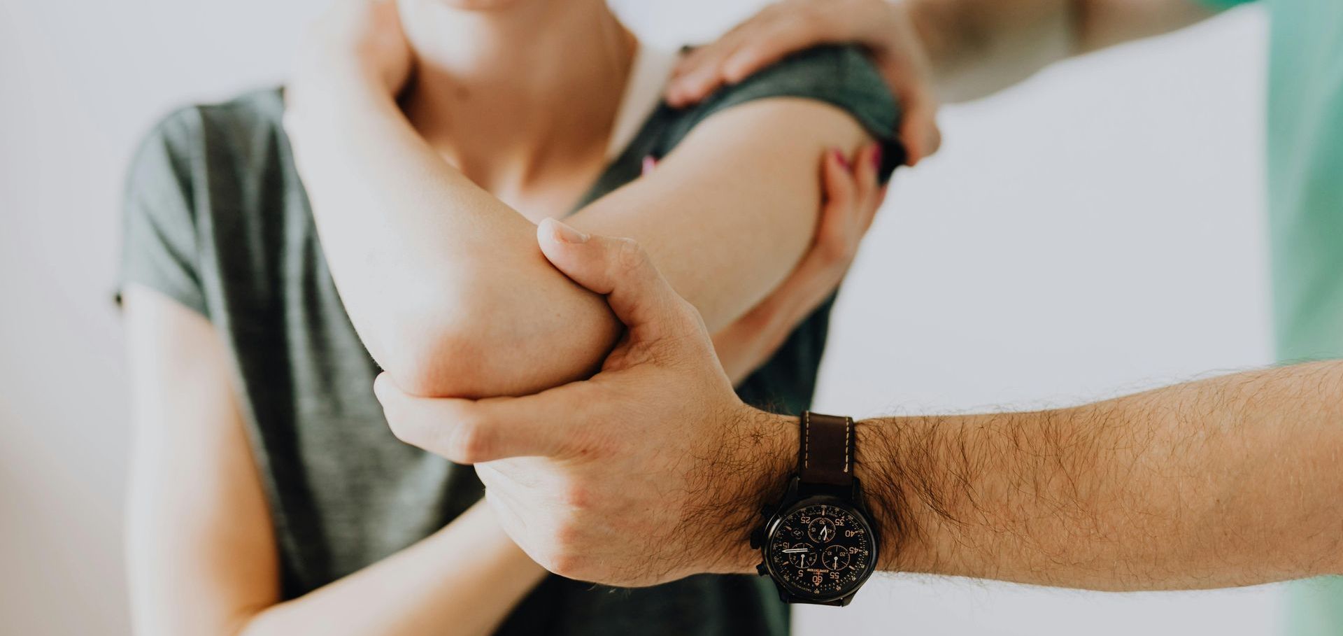 A woman is getting her elbow examined by a doctor.