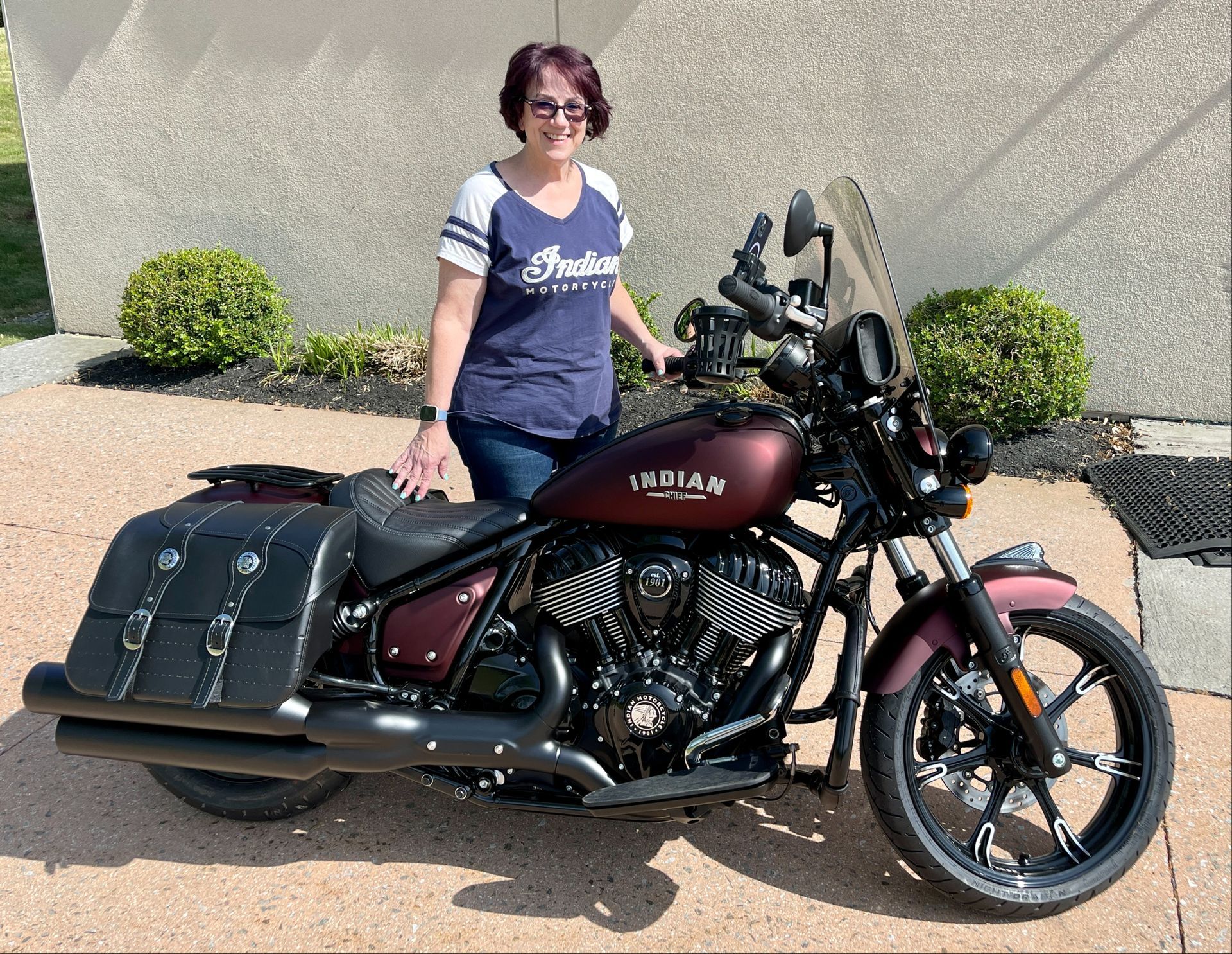 A woman is standing next to a red motorcycle.