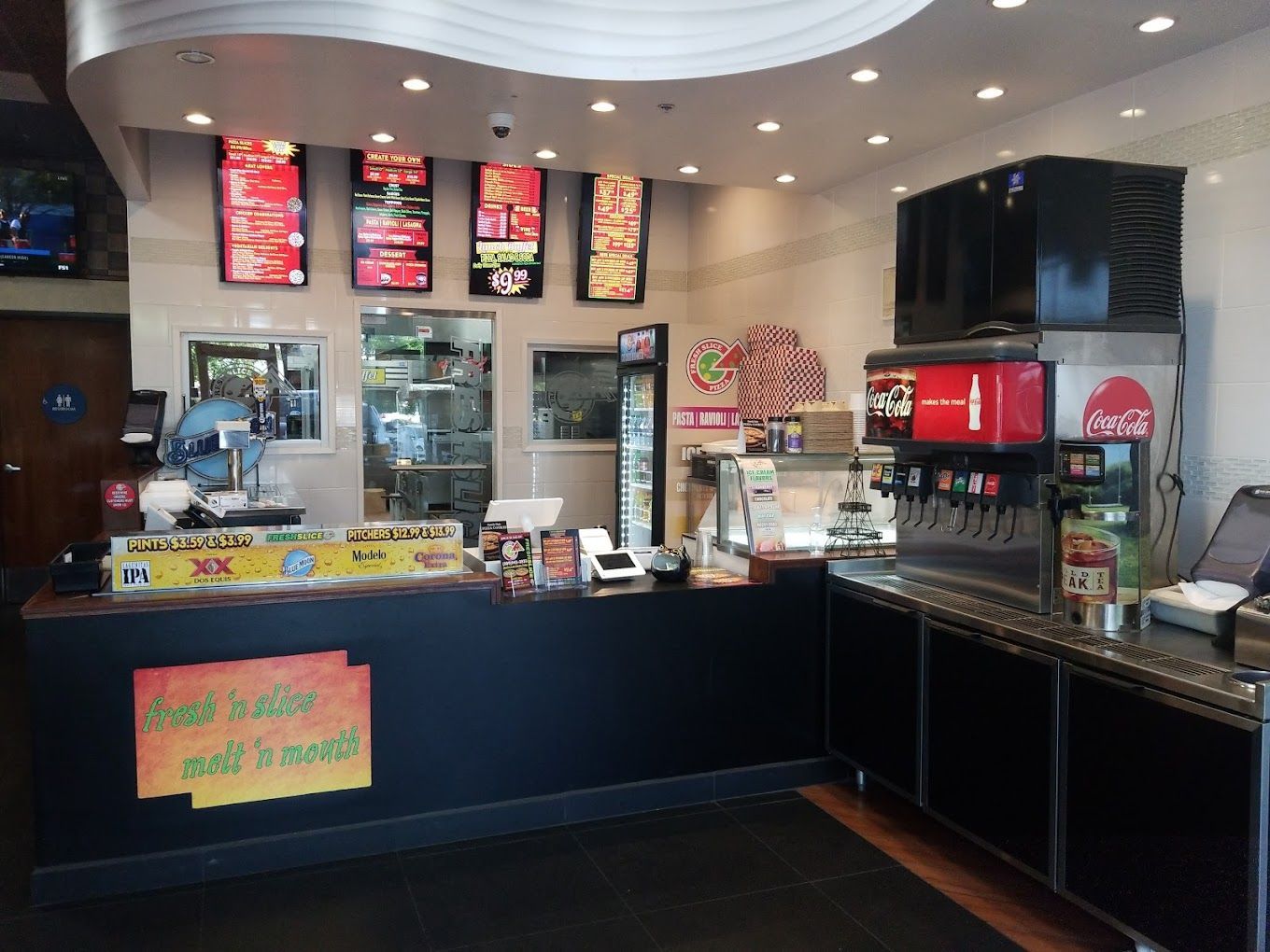 The inside of a restaurant with a coca cola machine