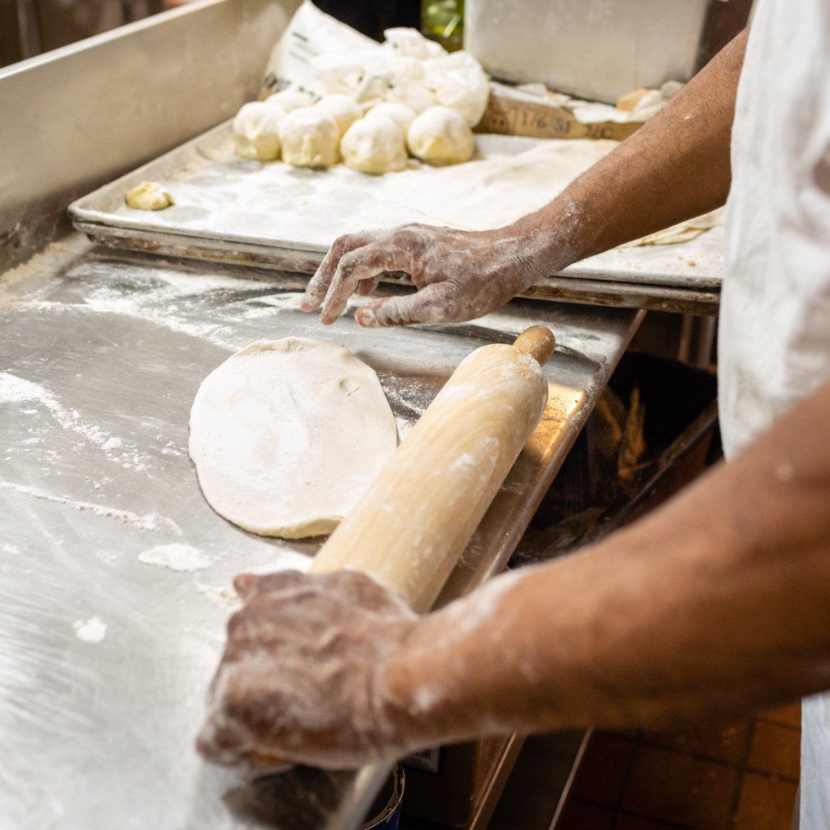 A person is rolling out dough with a rolling pin