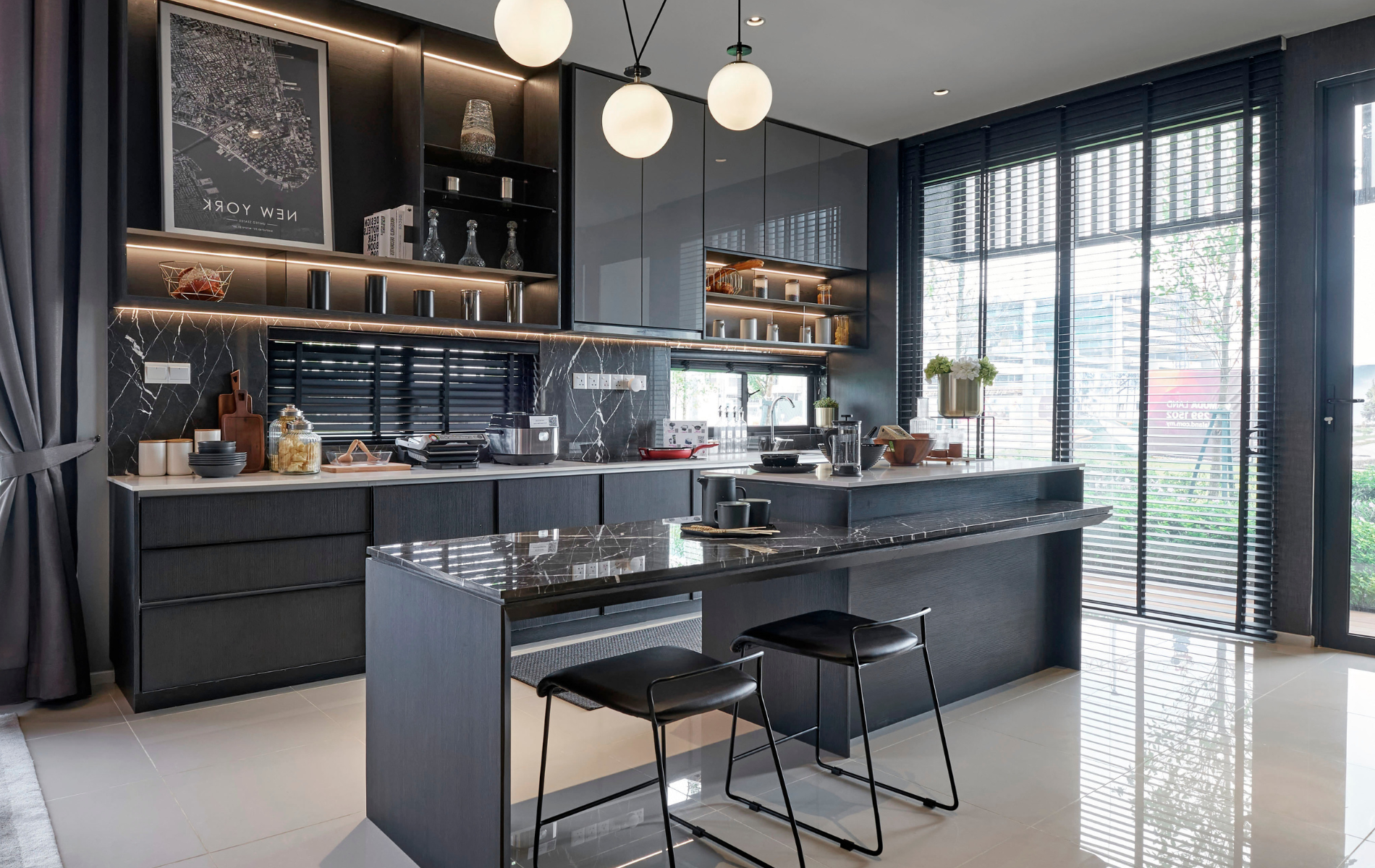 Modern gray kitchen with island, black countertops, and overhead lighting.