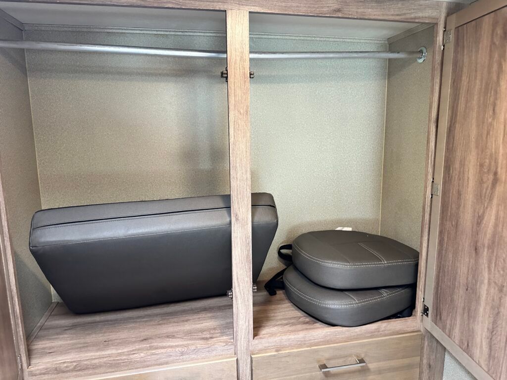 A closet with a couch and two chairs in it.