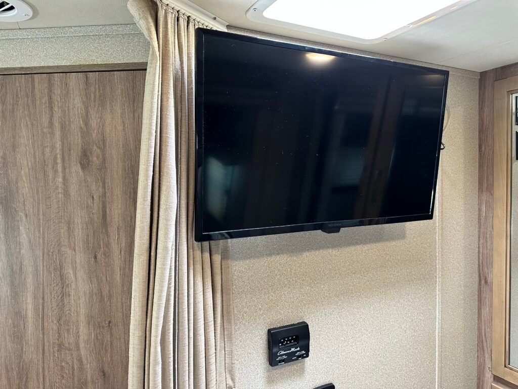 A flat screen tv is hanging on a wall in a rv.