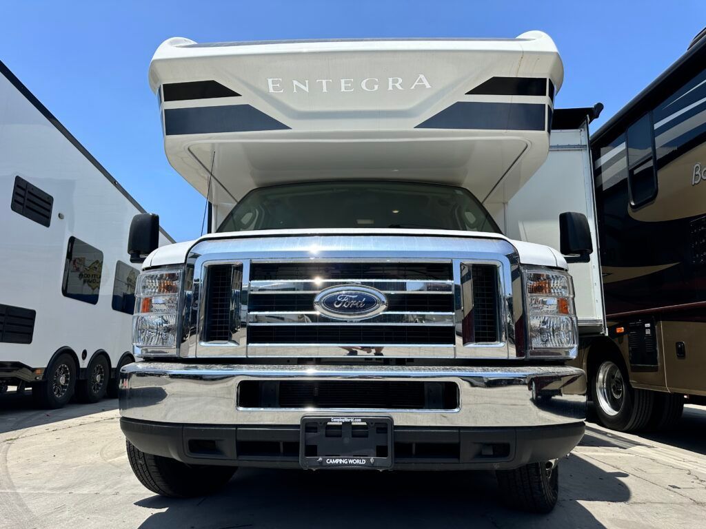 The front of a ford rv is parked in a parking lot.