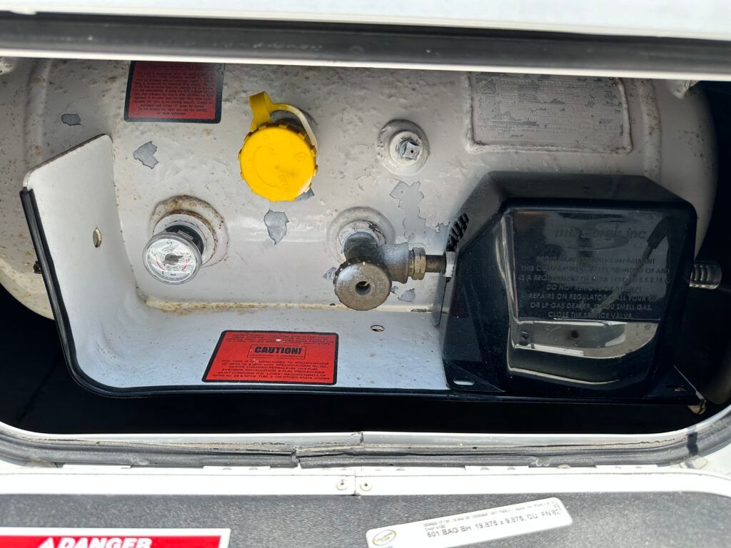 A close up of a gas tank with a yellow cap on it.