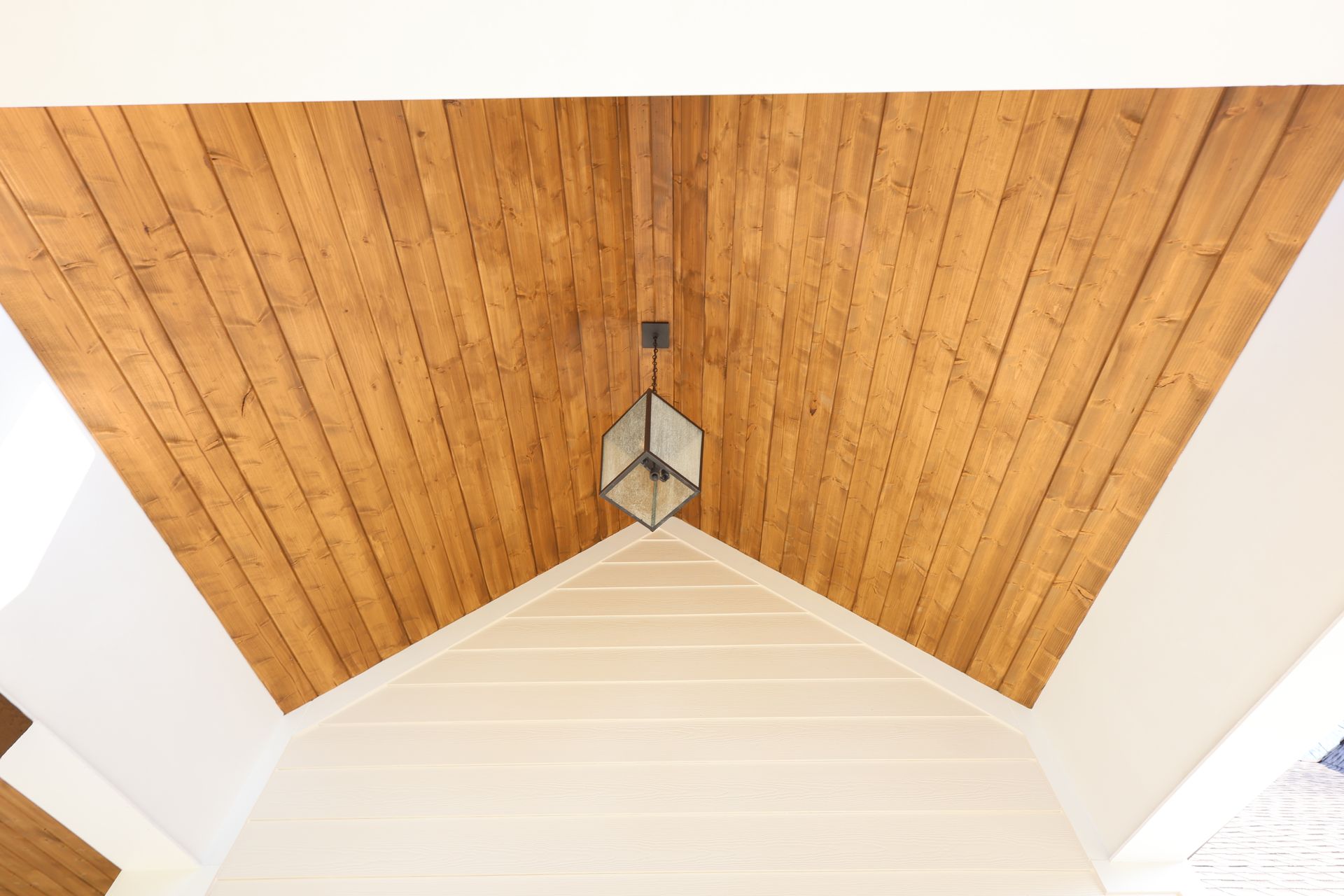 Wooden plank ceiling with a hanging geometric light fixture.