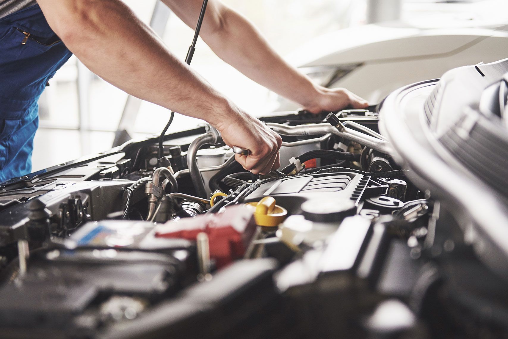 A man is working on the engine of a car.