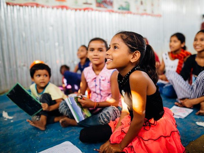 A group of children are sitting on the floor reading books.