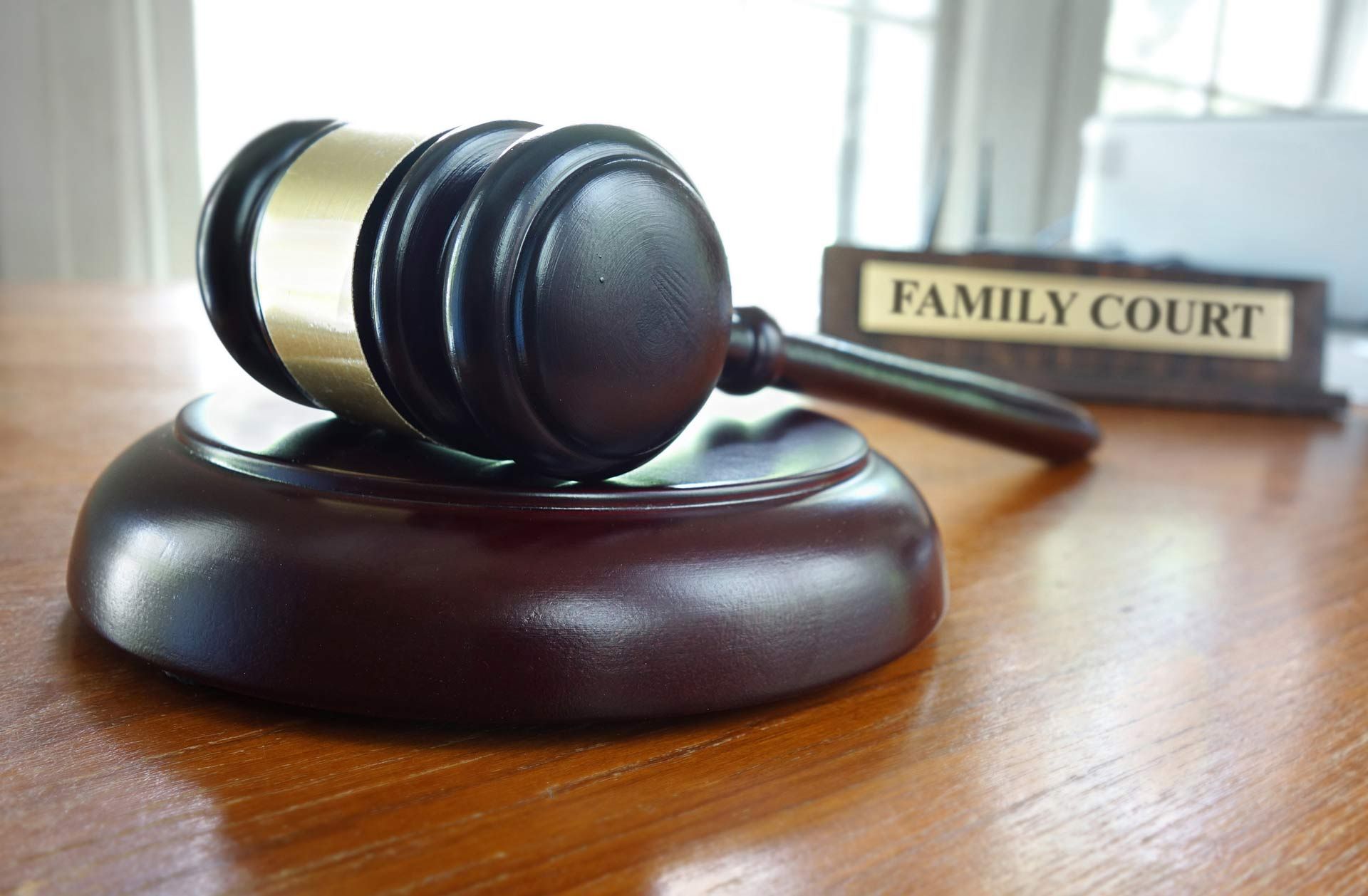 A judge 's gavel is sitting on a wooden table next to a sign that says family court.