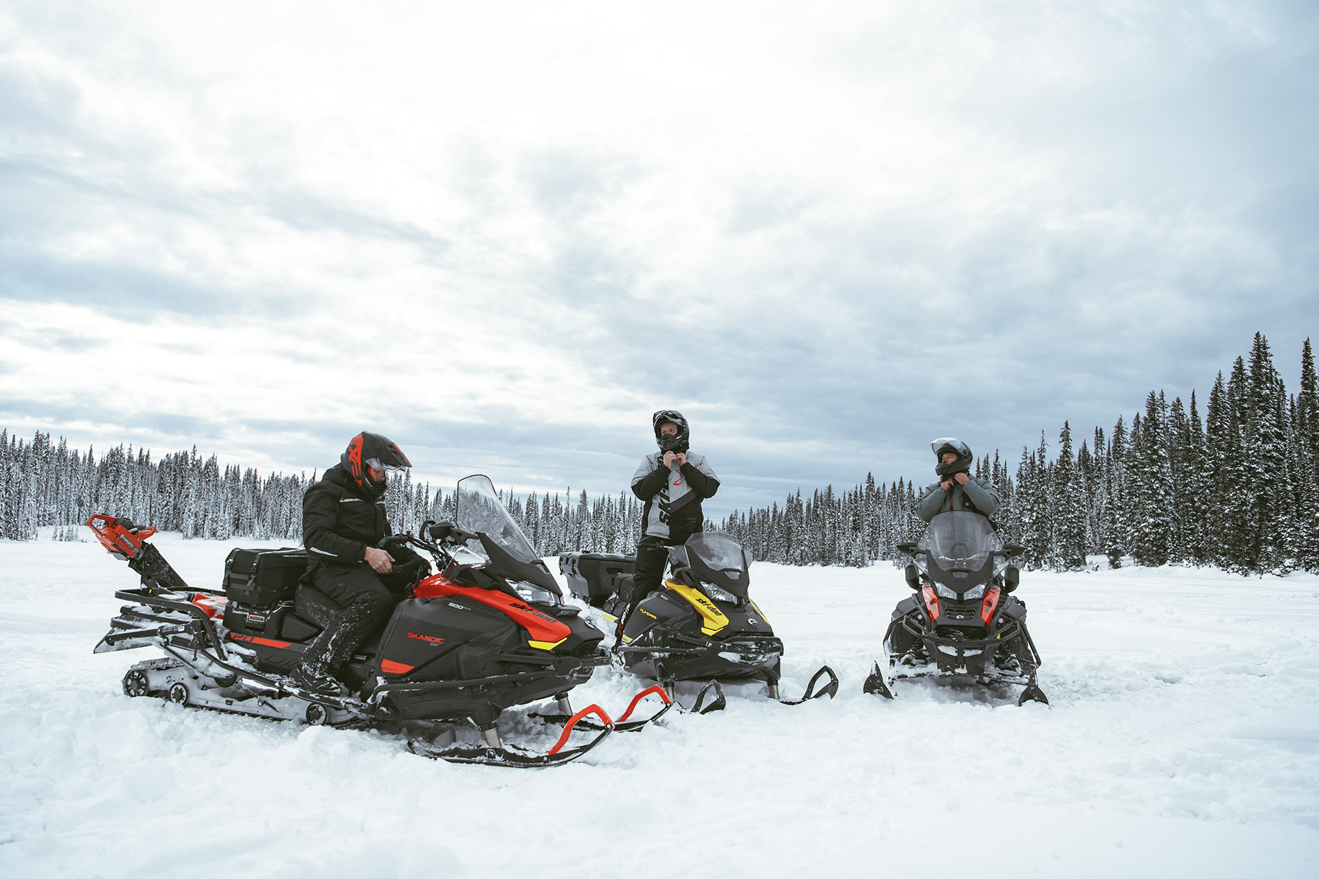 Three people on their snowmobiles