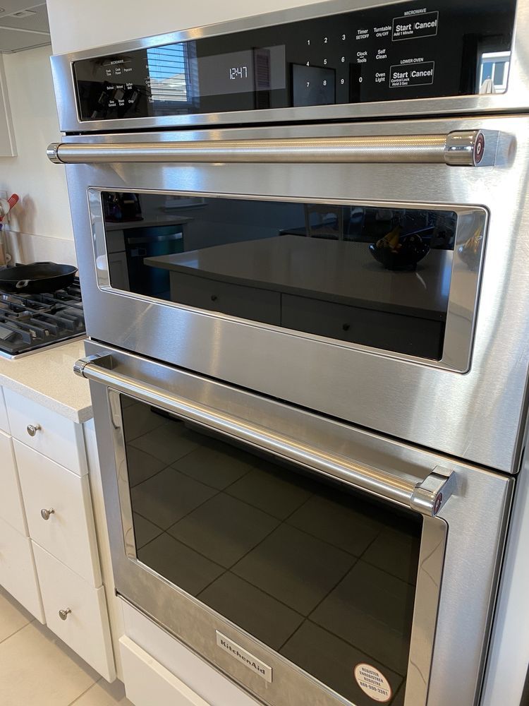 Stainless steel kitchen appliances: microwave oven and lower oven built into cabinetry.