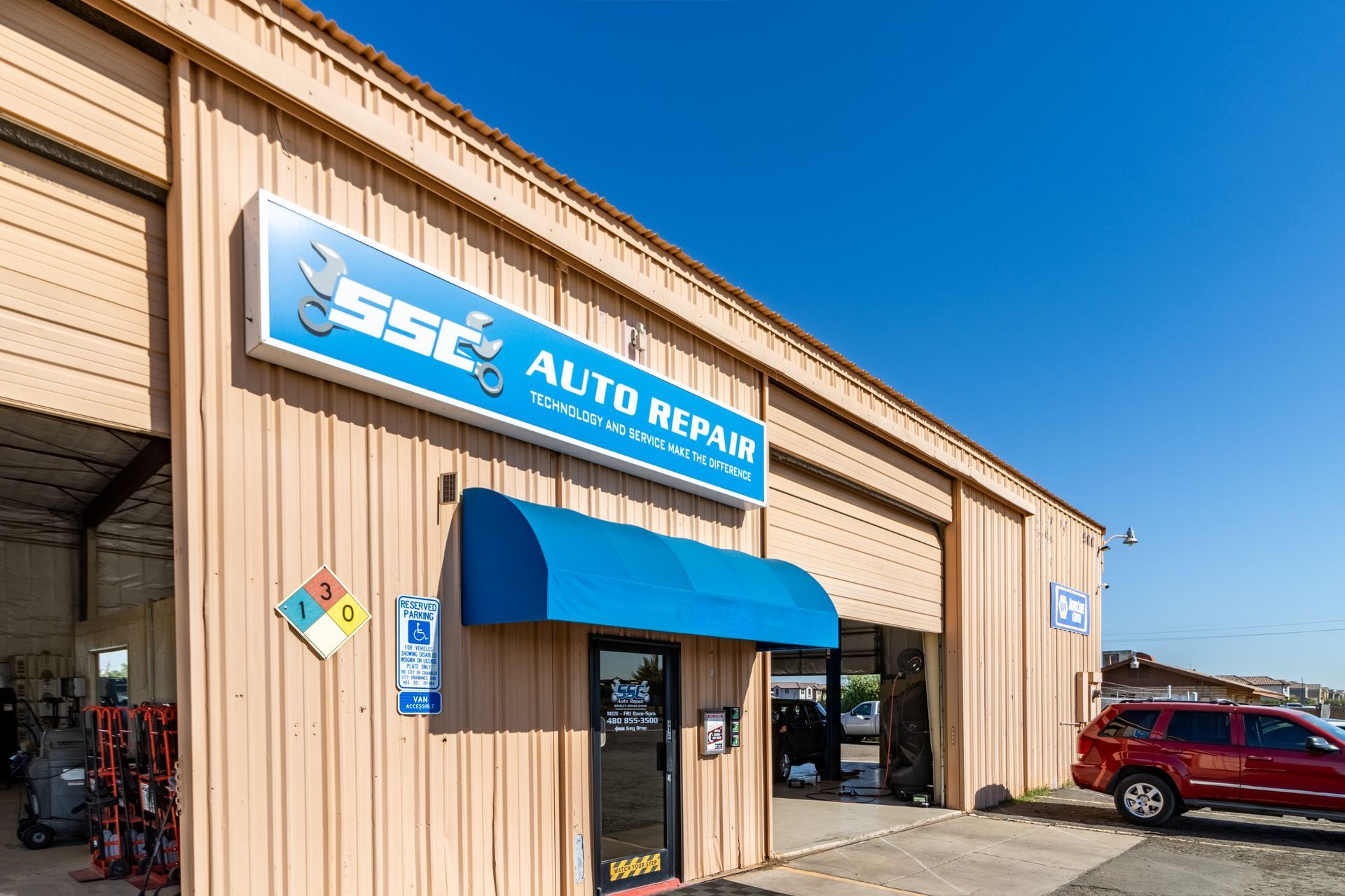 SSC Auto Repair storefront with a blue awning and a red SUV parked nearby.