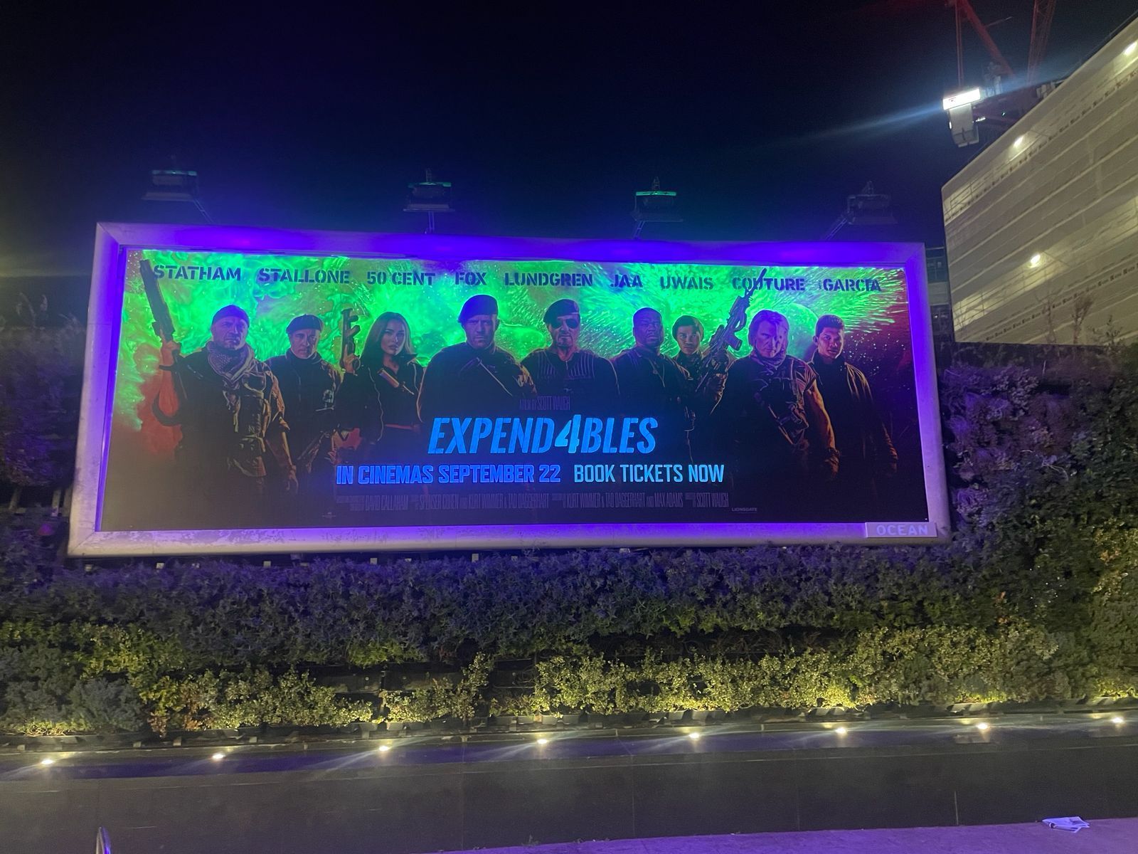 A large billboard with a picture of a group of people on it, UV lighting supplied by Absolute Events