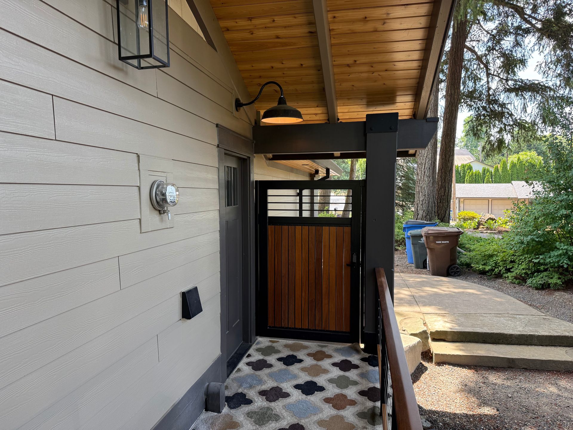 Dearey Residence side entry with wood plank gate and exposed ceiling beams in Washougal, WA