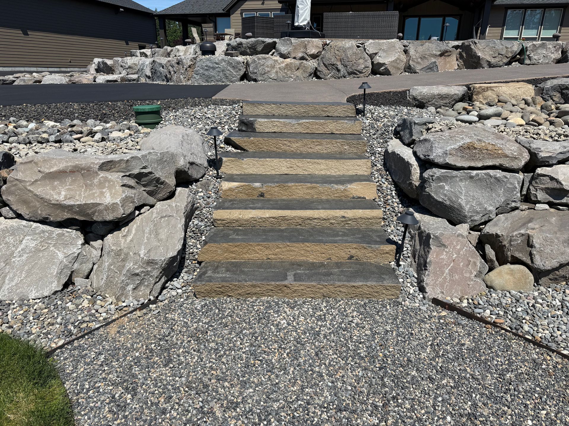 Stone landscape steps with large decorative boulders at a custom home in Washougal, WA