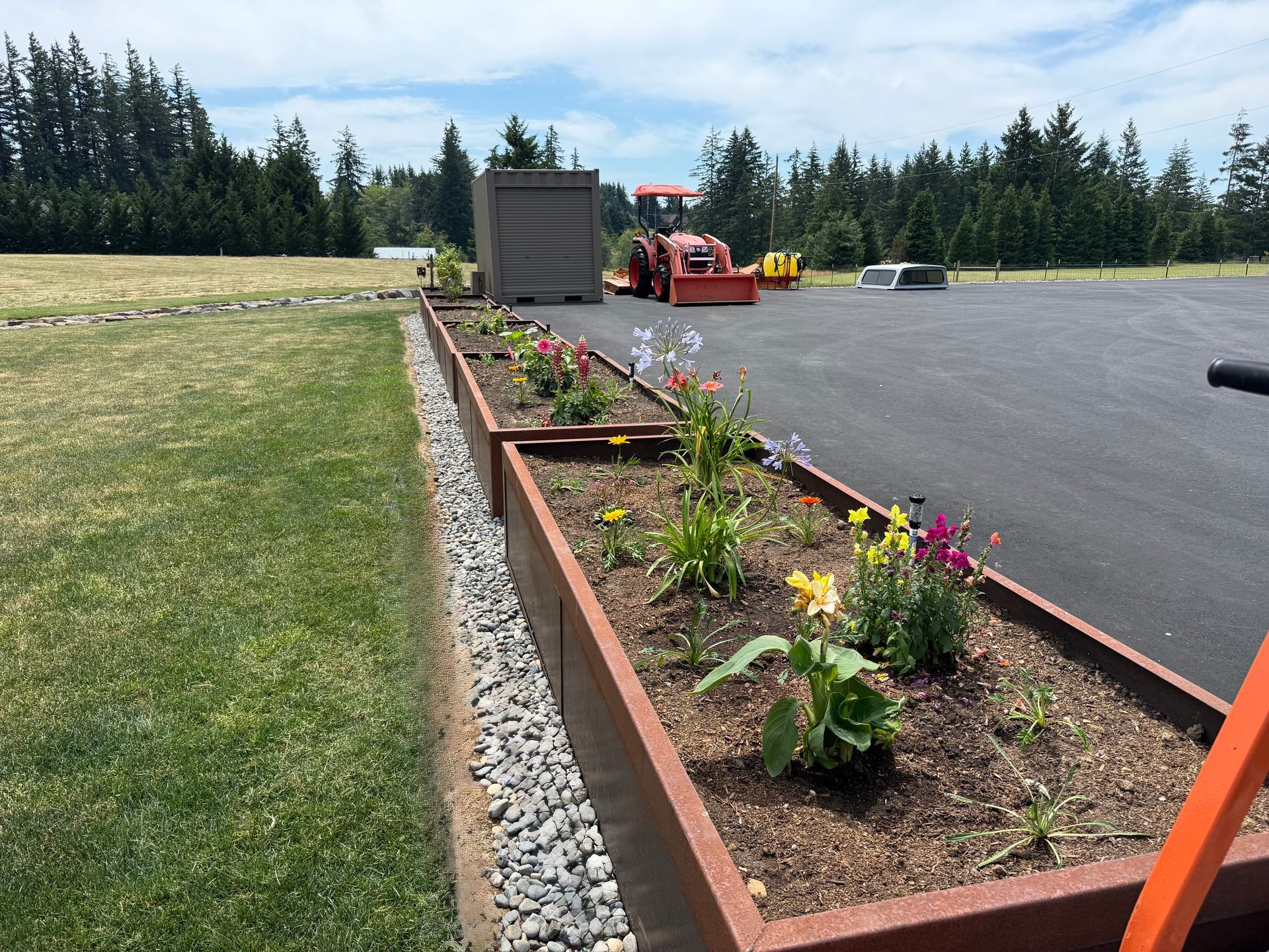 Raised flower bed landscaping with river rock border at custom home in Washougal, WA