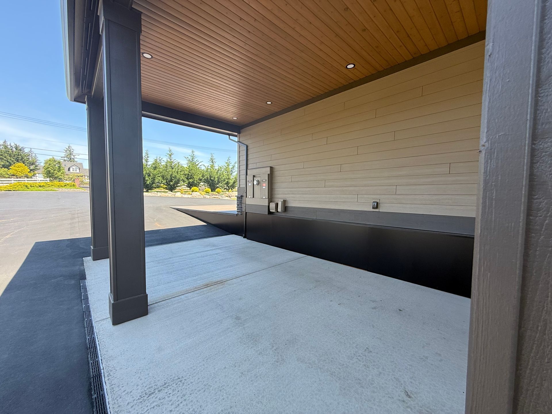 Covered carport with wood-paneled ceiling and modern siding at a Washougal custom home