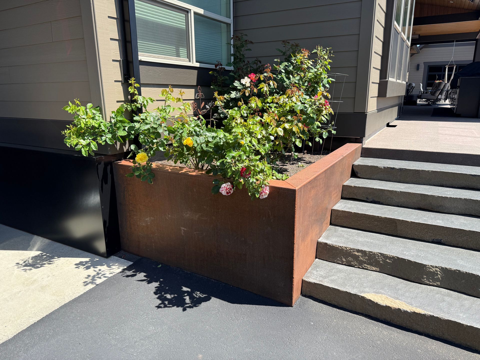 Custom steel garden planter beside concrete steps at a luxury home in Washougal, WA