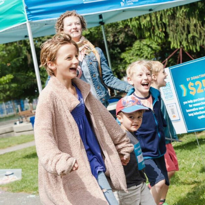 A mom and her children are laughing together outside at The Walk.