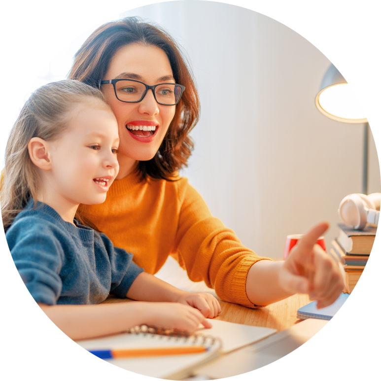 A mom and her young daughter look and smile at the laptop screen.