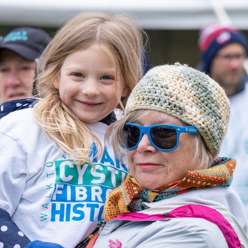 Une femme âgée et sa petite-fille, portant des t-shirts de la Marche, sourient à la caméra lors de l’événement.