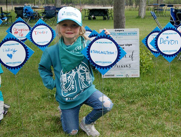 A young girl at the CF Walk 2022 event holding up a sign hatred, Teighan's Team
