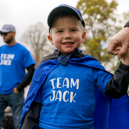A little girl sits on her father's shoulders as they participate in the walk
