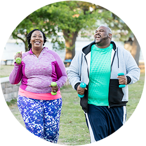 An older couple walking briskly with weights