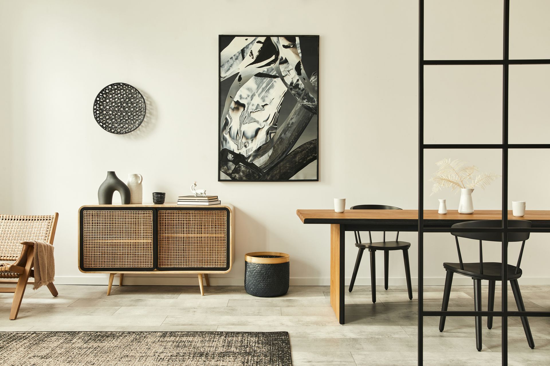 Dining room with wooden table and chairs, sideboard, art, and patterned rug. Dining room with wooden table and chairs, sideboard, art, and patterned rug.