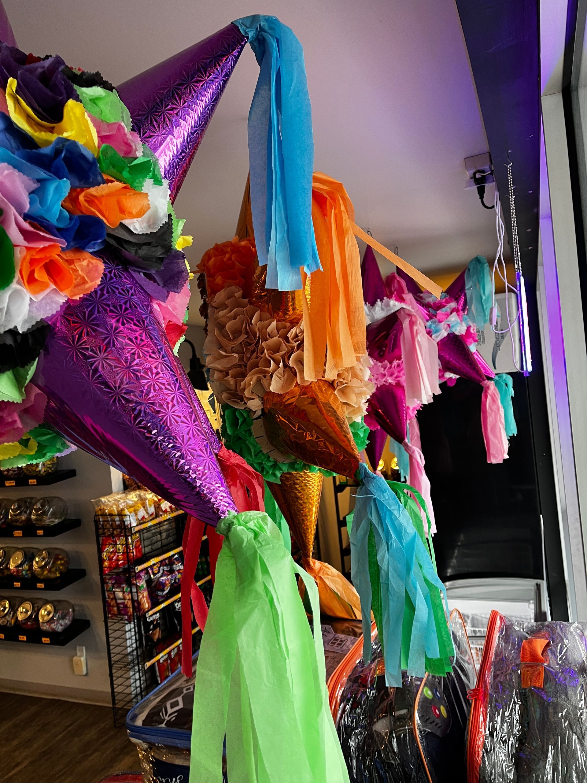 A colorful pinata is hanging from the ceiling in a store.