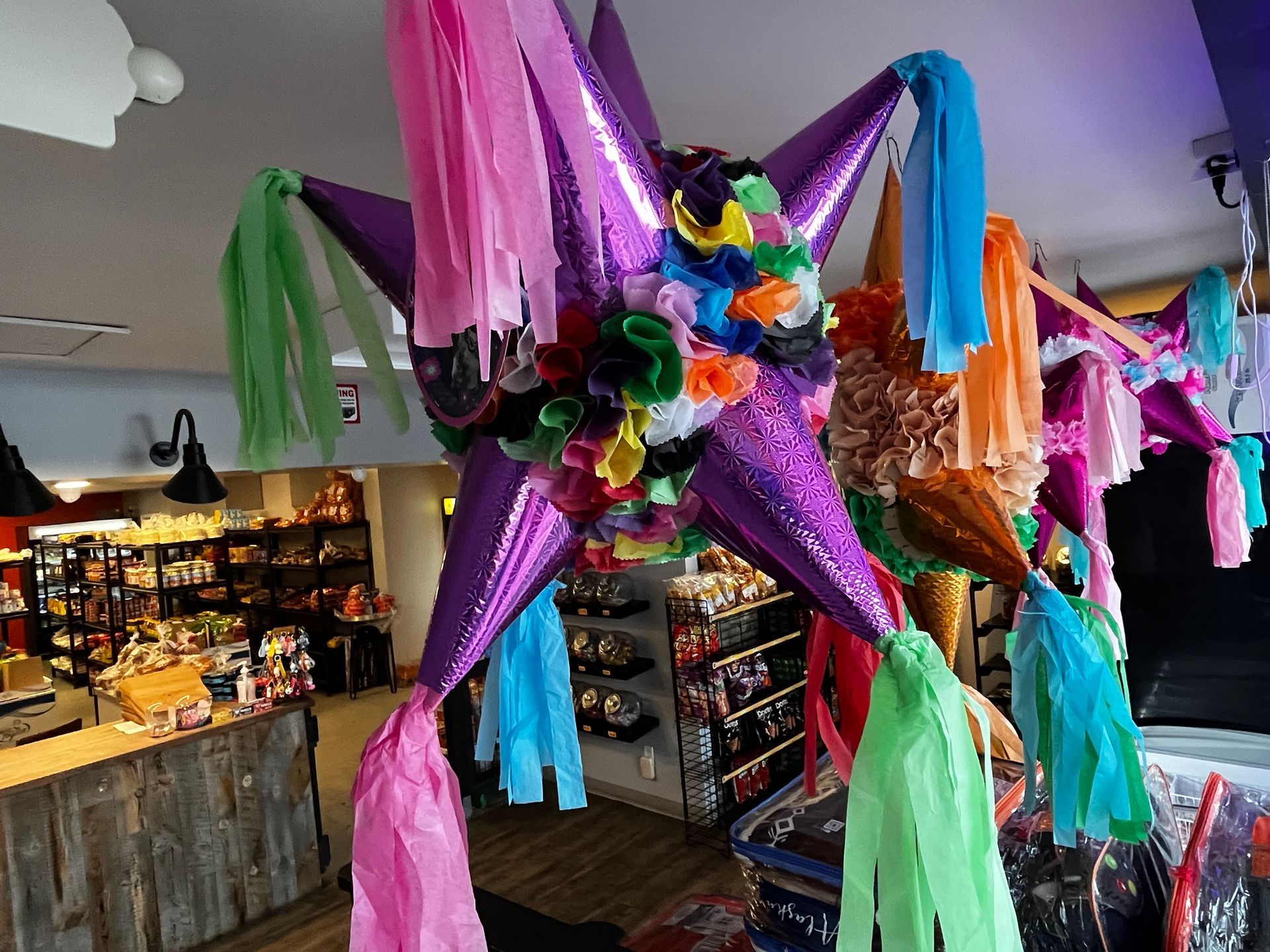 A colorful pinata is hanging from the ceiling in a store.