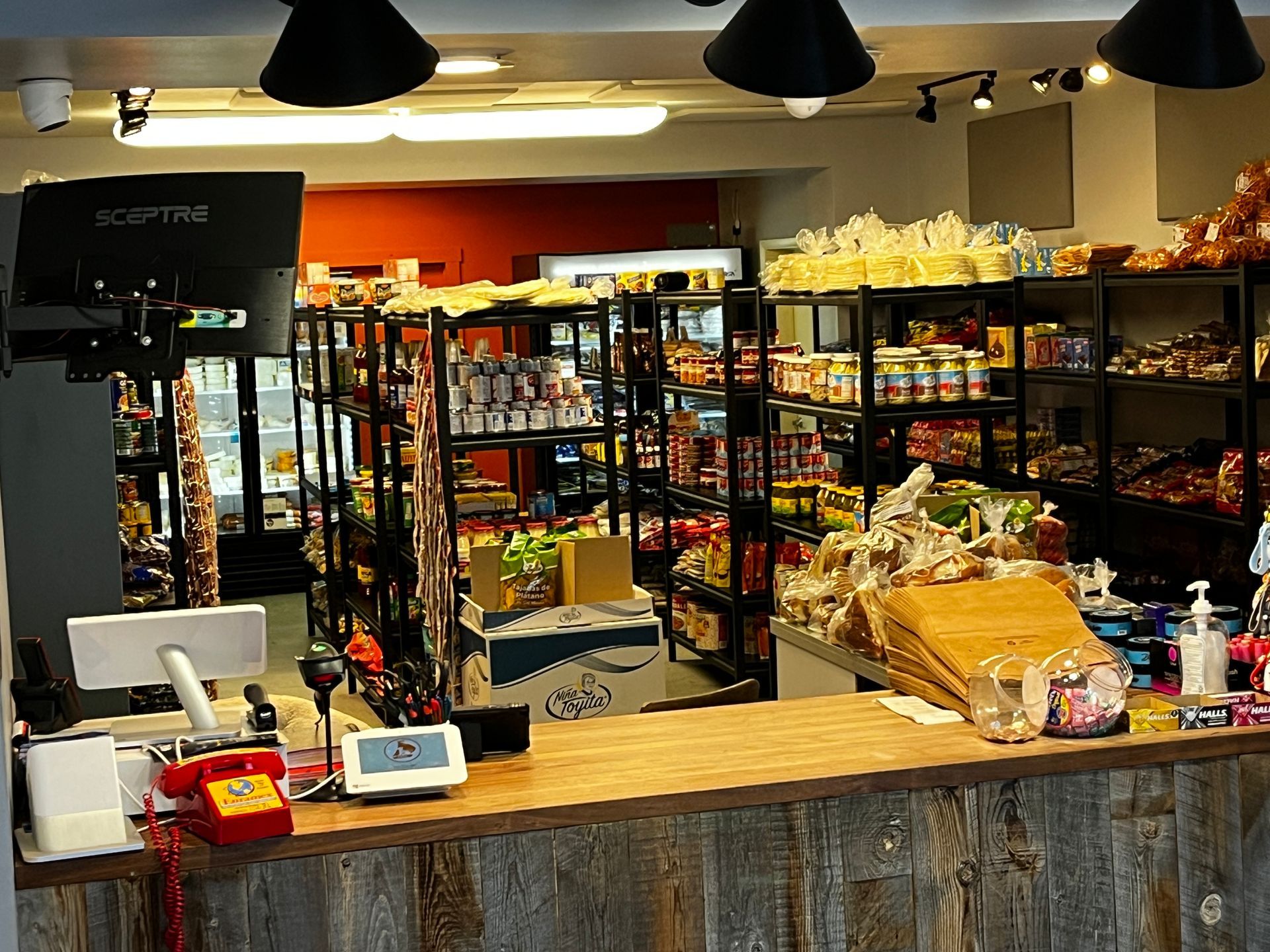 The inside of a grocery store with a wooden counter.