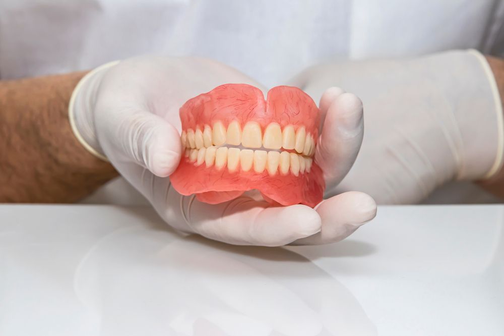Dentist Holding Dentures for Relining