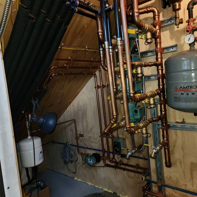 Copper pipes and heating equipment installed in a wall corner.