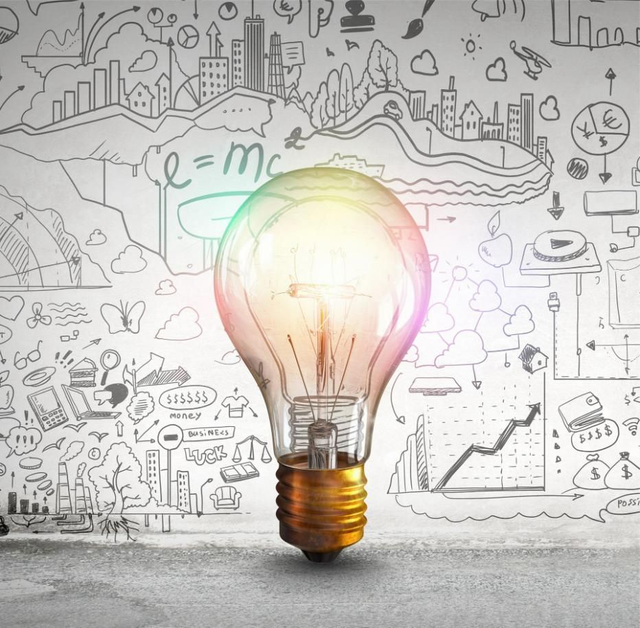 A Light Bulb In Front Of A Wall With Drawings On It — Classic Design & Print in Svensson Heights, QLD
