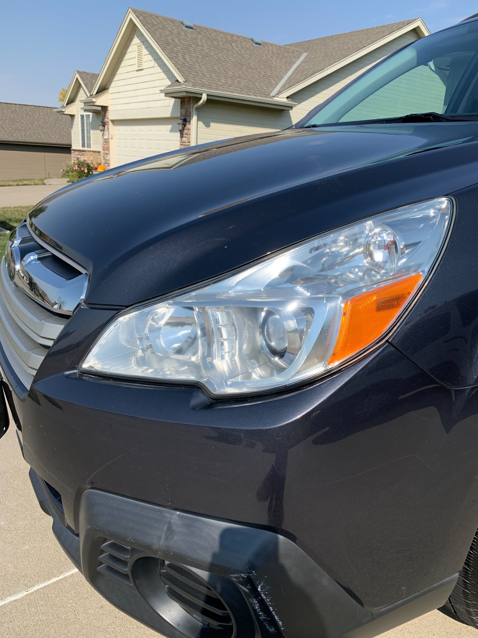 A black car is parked in front of a house.