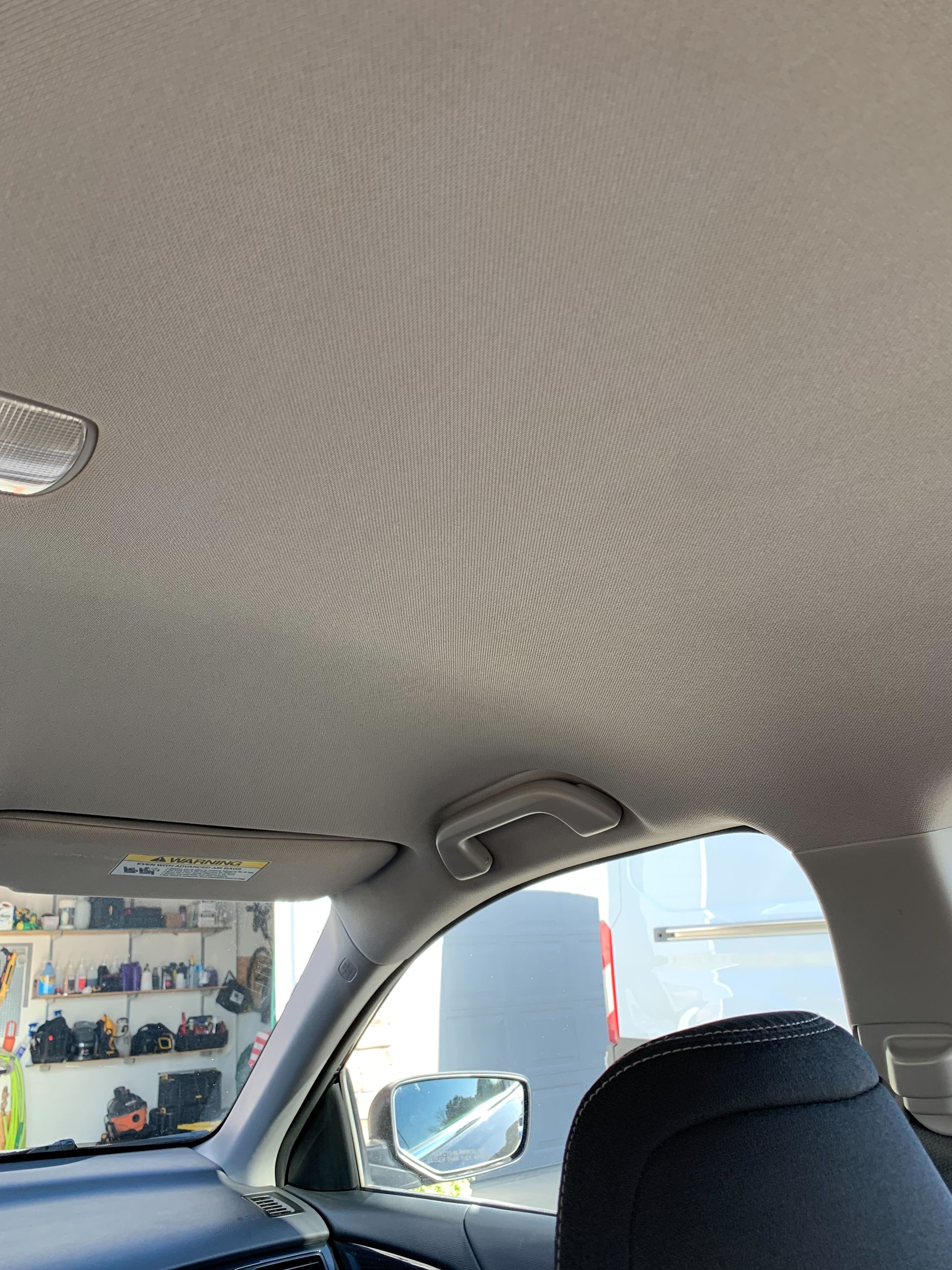 The ceiling of a car with a few holes in it