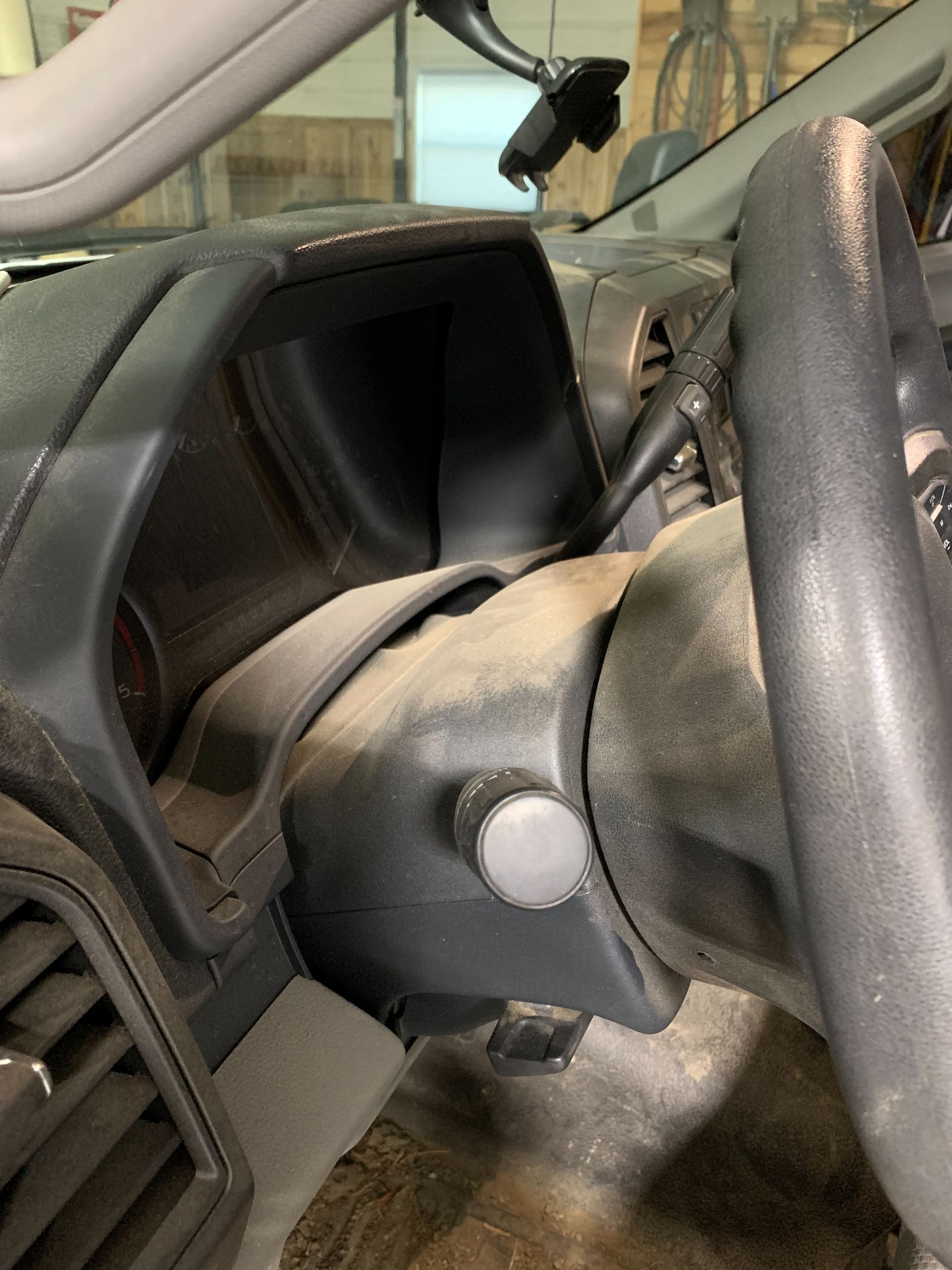 A close up of a car steering wheel and dashboard