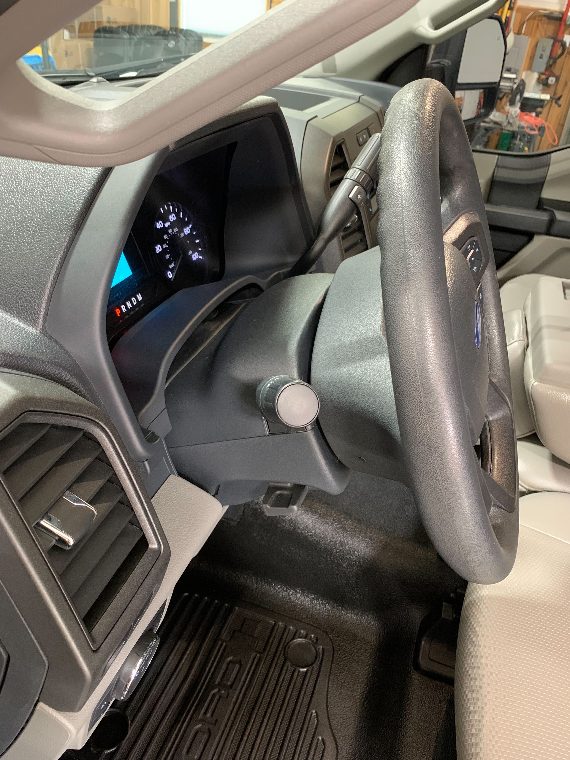The inside of a car with a steering wheel and dashboard.
