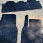 A close up of a set of three black mats on a table.