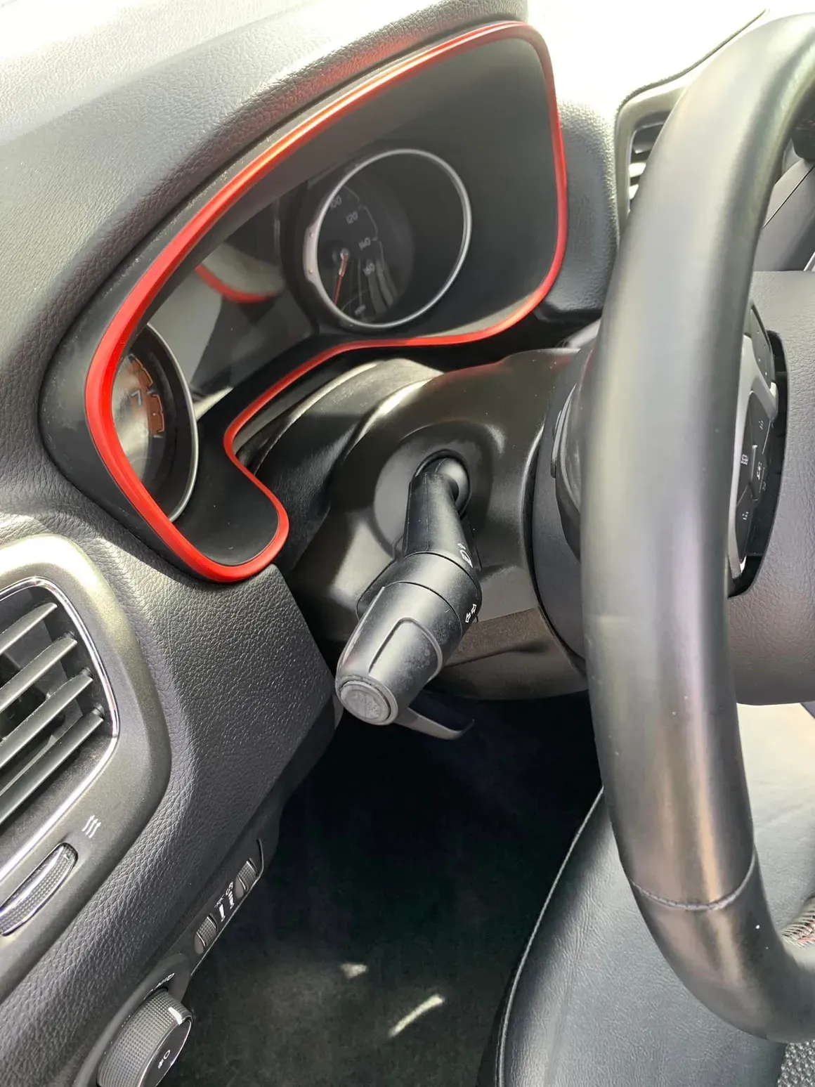 A close up of a car dashboard with a red trim