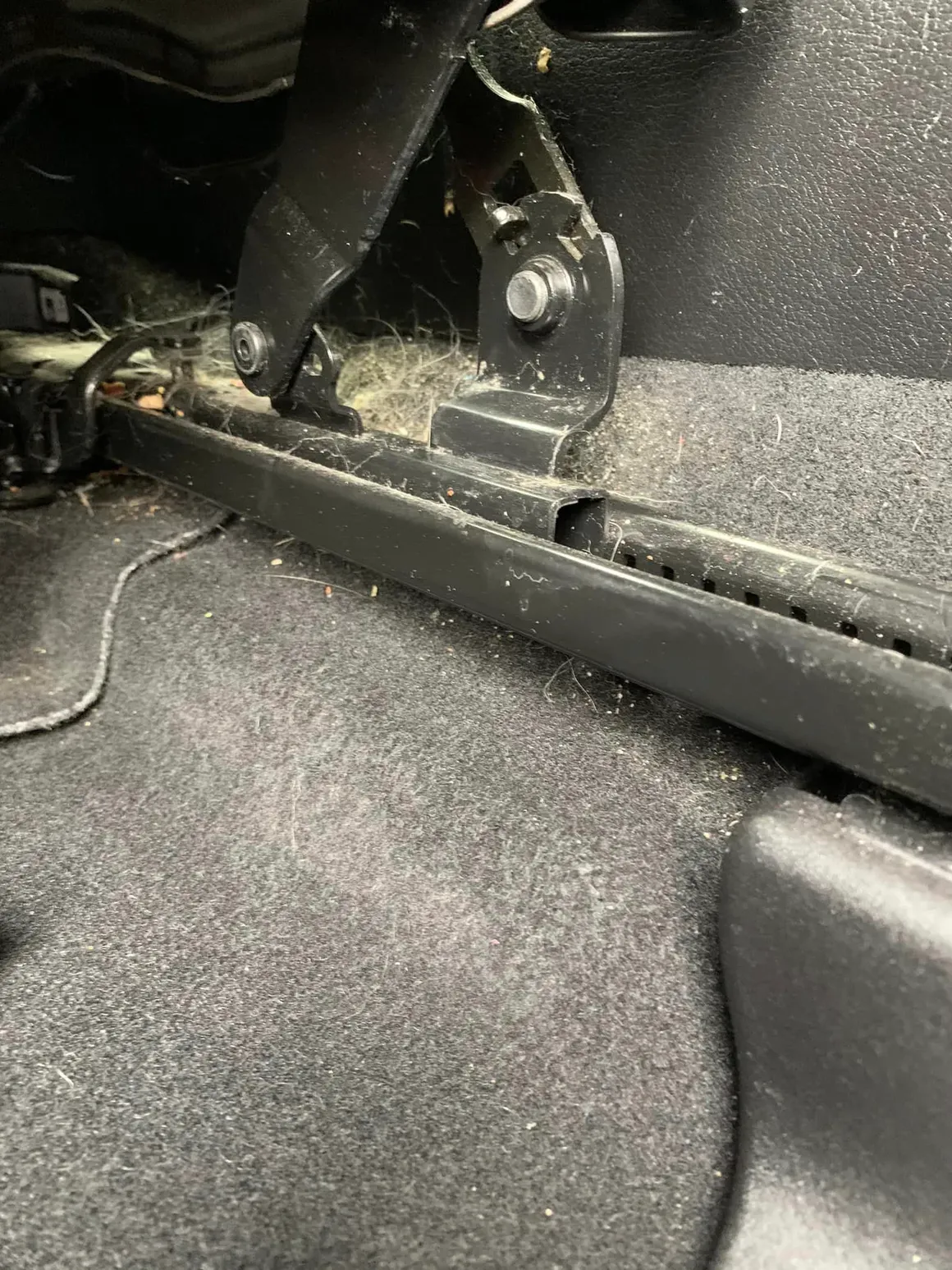 A close up of the bottom of a car with a lot of dust on it.